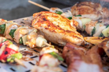 Tavuk göğsü ve domuz eti taze renkli ve lezzetli sebzelerle ahşap şişte çekiliyor.