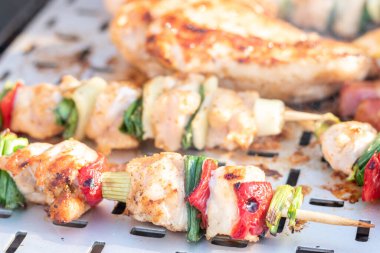 Tavuk göğsü ve domuz eti taze renkli ve lezzetli sebzelerle ahşap şişte çekiliyor.
