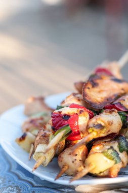 Tavuk göğsü ve domuz eti taze renkli ve lezzetli sebzelerle ahşap şişte çekiliyor.