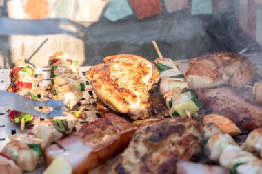 Tavuk göğsü ve domuz eti taze renkli ve lezzetli sebzelerle ahşap şişte çekiliyor.