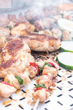 Tavuk göğsü ve domuz eti taze renkli ve lezzetli sebzelerle ahşap şişte çekiliyor.