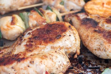 Tavuk göğsü ve domuz eti taze renkli ve lezzetli sebzelerle ahşap şişte çekiliyor.