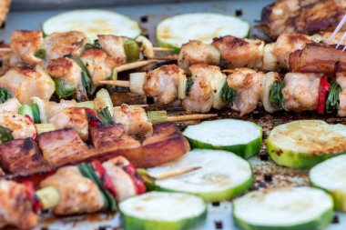 Tavuk göğsü ve domuz eti taze renkli ve lezzetli sebzelerle ahşap şişte çekiliyor.