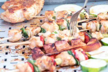 Tavuk göğsü ve domuz eti taze renkli ve lezzetli sebzelerle ahşap şişte çekiliyor.