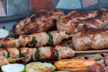 Tavuk göğsü ve domuz eti taze renkli ve lezzetli sebzelerle ahşap şişte çekiliyor.