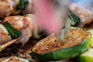 Tavuk göğsü ve domuz eti taze renkli ve lezzetli sebzelerle ahşap şişte çekiliyor.