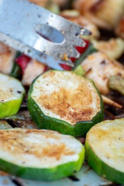 Tavuk göğsü ve domuz eti taze renkli ve lezzetli sebzelerle ahşap şişte çekiliyor.