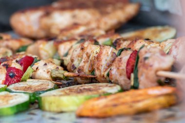 Tavuk göğsü ve domuz eti taze renkli ve lezzetli sebzelerle ahşap şişte çekiliyor.