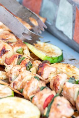 Tavuk göğsü ve domuz eti taze renkli ve lezzetli sebzelerle ahşap şişte çekiliyor.