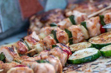 Tavuk göğsü ve domuz eti taze renkli ve lezzetli sebzelerle ahşap şişte çekiliyor.