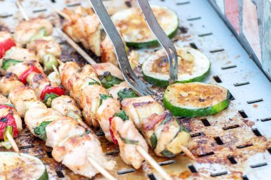 Tavuk göğsü ve domuz eti taze renkli ve lezzetli sebzelerle ahşap şişte çekiliyor.