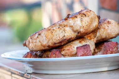 Tavuk göğsü ve domuz eti taze renkli ve lezzetli sebzelerle ahşap şişte çekiliyor.