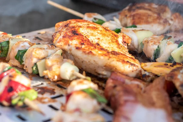 Tavuk göğsü ve domuz eti taze renkli ve lezzetli sebzelerle ahşap şişte çekiliyor.