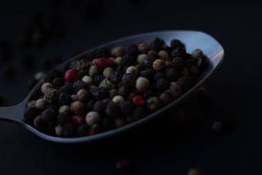 Various colored pepercorns on a dark background