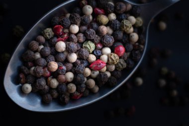 Various colored pepercorns on a dark background