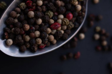 Various colored pepercorns on a dark background