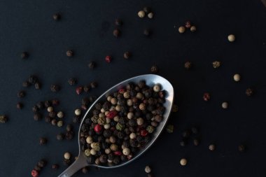 Various colored pepercorns on a dark background