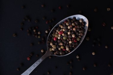 Various colored pepercorns on a dark background