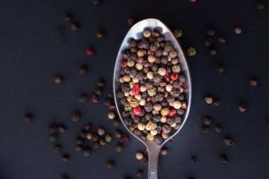 Various colored pepercorns on a dark background