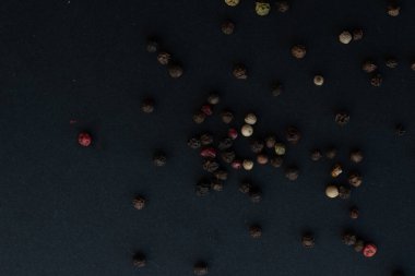Various colored pepercorns on a dark background