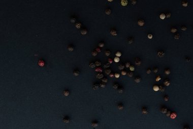 Various colored pepercorns on a dark background