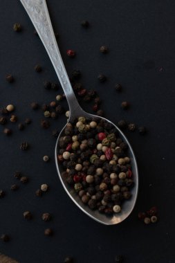 Various colored pepercorns on a dark background