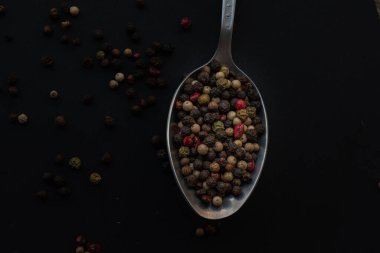 Various colored pepercorns on a dark background