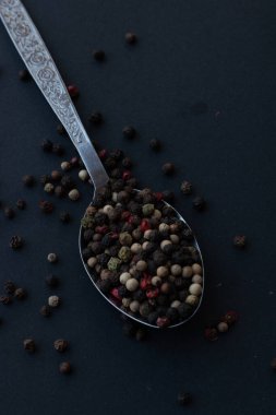 Various colored pepercorns on a dark background