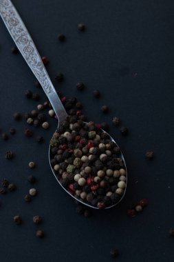 Various colored pepercorns on a dark background