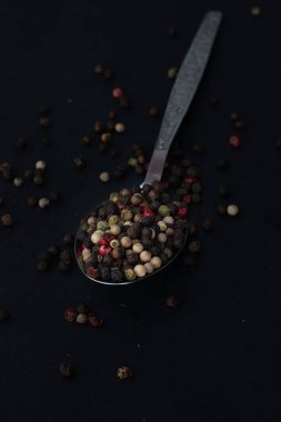 Various colored pepercorns on a dark background