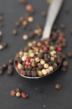 Various colored pepercorns on a dark background