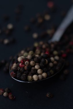 Various colored pepercorns on a dark background