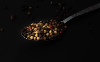 Various colored pepercorns on a dark background