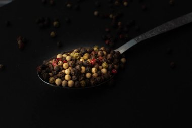 Various colored pepercorns on a dark background