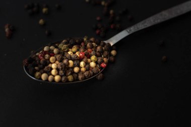 Various colored pepercorns on a dark background