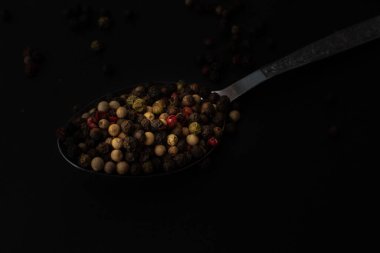 Various colored pepercorns on a dark background