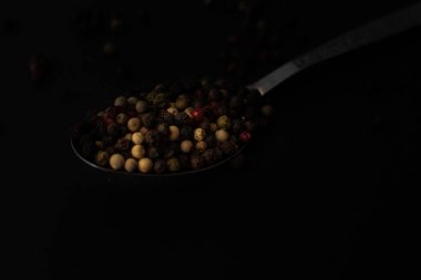 Various colored pepercorns on a dark background