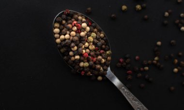Various colored pepercorns on a dark background
