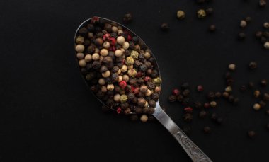 Various colored pepercorns on a dark background