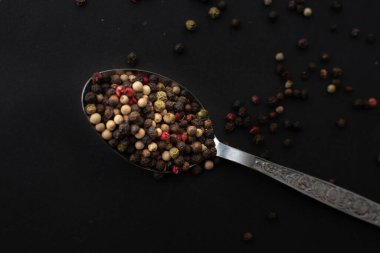 Various colored pepercorns on a dark background