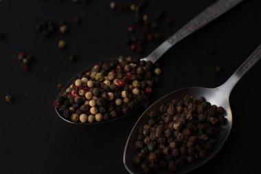 Various colored pepercorns on a dark background