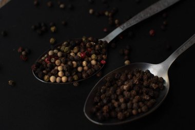 Various colored pepercorns on a dark background
