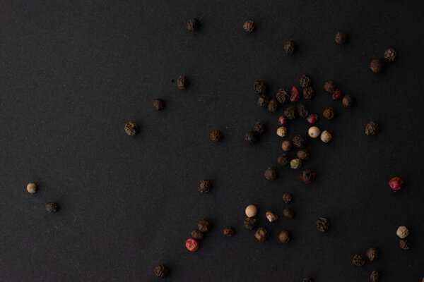 Various colored pepercorns on a dark background