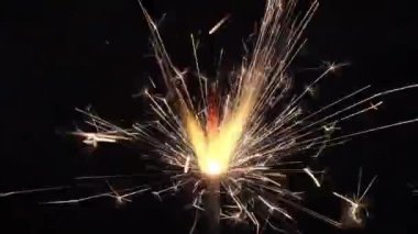 Siyah bir arka planda neşeli bir maytap yanıyor.