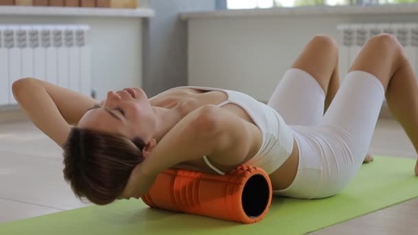 Mujer haciendo ejercicios de rodillo de espuma para aliviar el dolor de espalda — Vídeo de stock