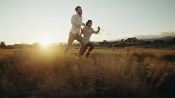 Par kører i en mark ved solnedgang lys – Stock-video