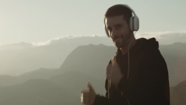 Boy walks and listen music in headphones — Vídeo de stock