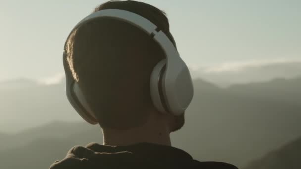 Guy listening music in headphones outdoor — Stockvideo