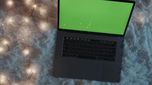Laptop cu ecran verde pe covorul alb noaptea — Videoclip de stoc