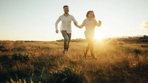 Heureux couple courir en plein air au coucher du soleil lumière — Photo